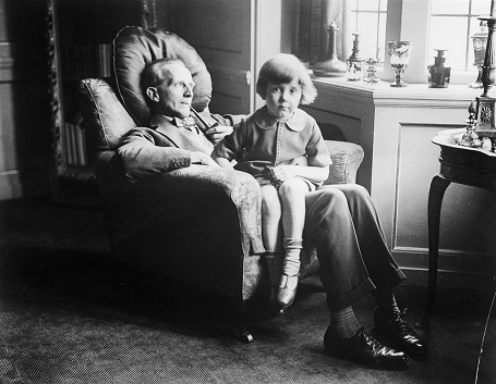 Cậu bé Christopher Robin 5 tuổi đang ngồi trong lòng cha - nhà văn AA Milne. Chứng kiến tuổi thơ của con đã khiến AA Milne sáng tạo nên những câu chuyện nổi tiếng dành cho thiếu nhi.